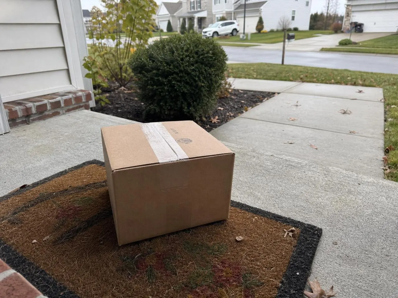 Discreet NovaPept shipping box left on a suburban American front porch welcome mat
