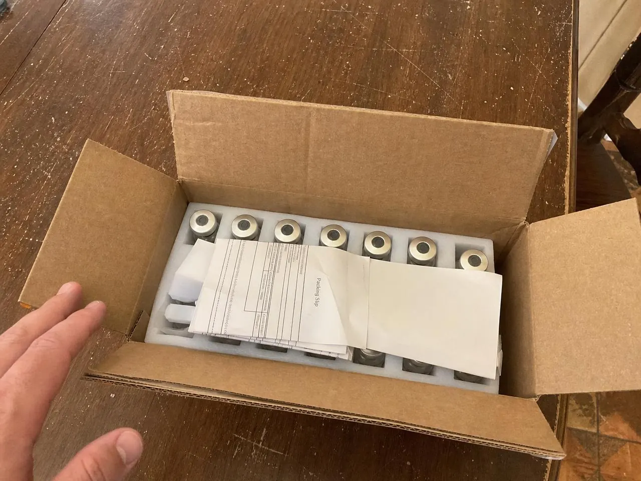 Open shipping box showing peptide vials safely secured in protective foam inserts